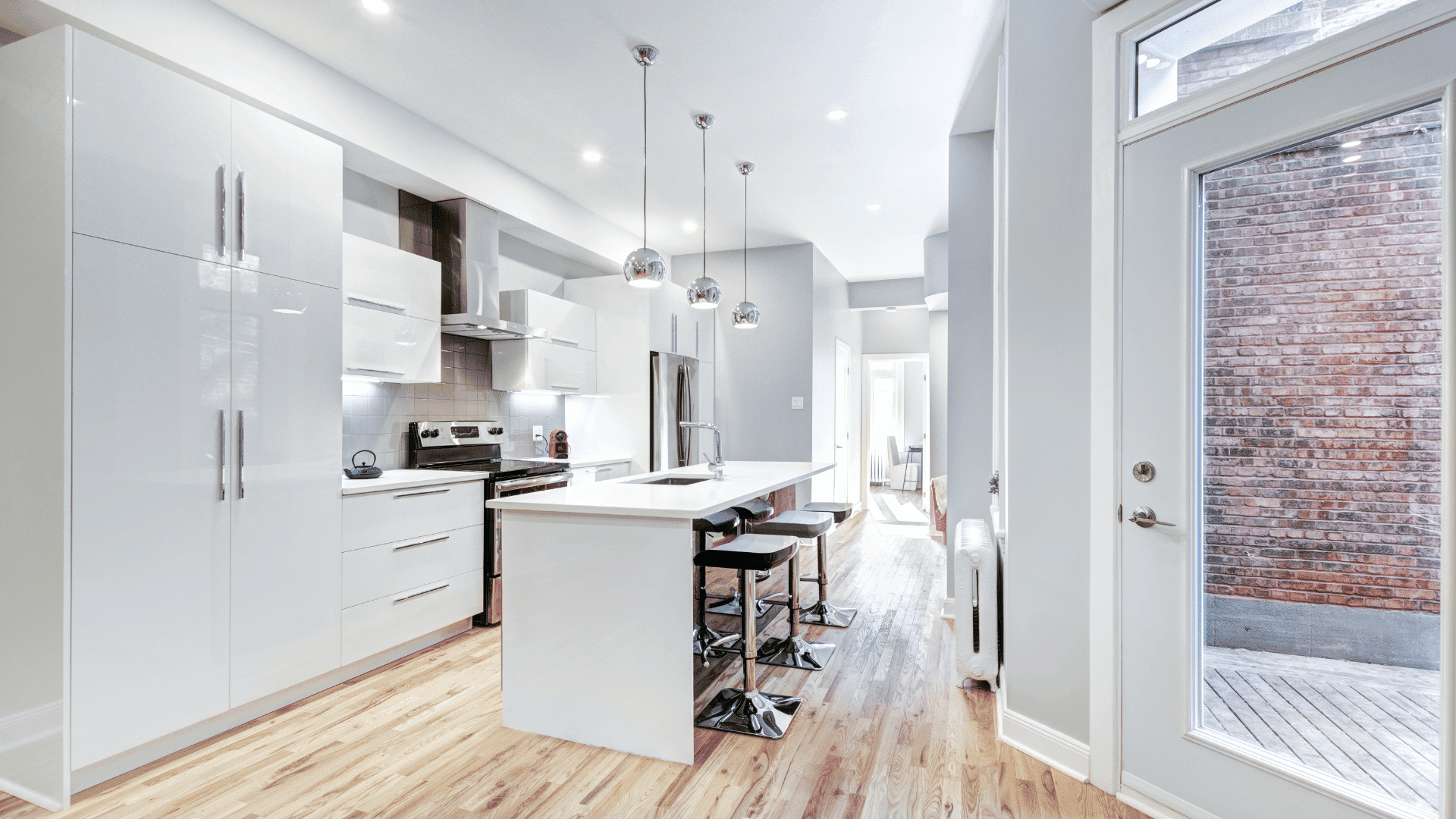 Fully renovated kitchen in white tones and wood flooring